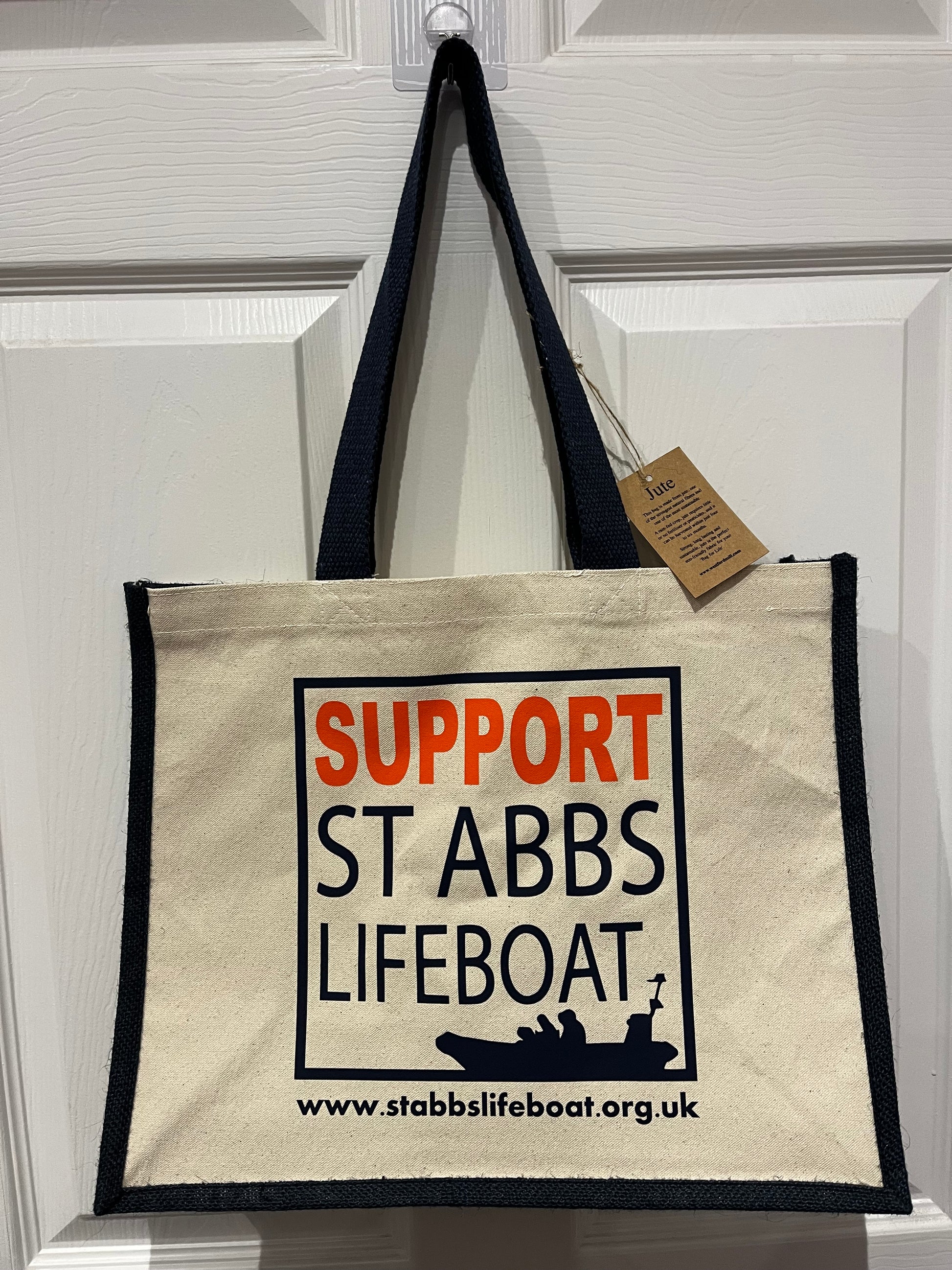 A large jute shopping bag with the Support St Abbs logo printed on the front